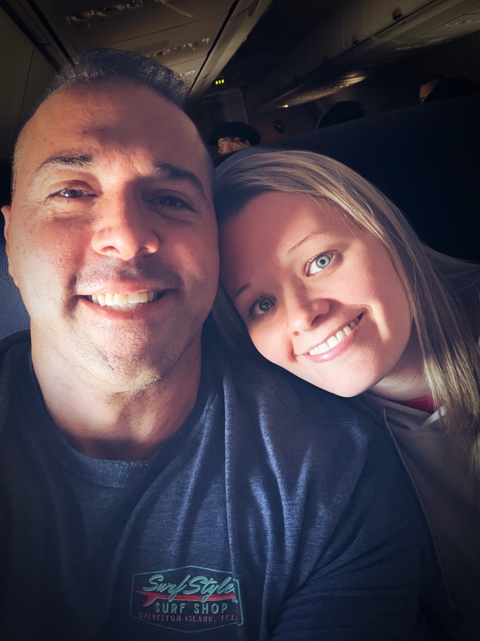 Jordan and Danielle leaning together in airplane seats